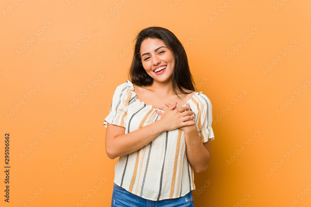Young curvy woman has friendly expression, pressing palm to chest. Love concept. Young curvy woman has friendly expression, pressing palm to chest. Love concept.