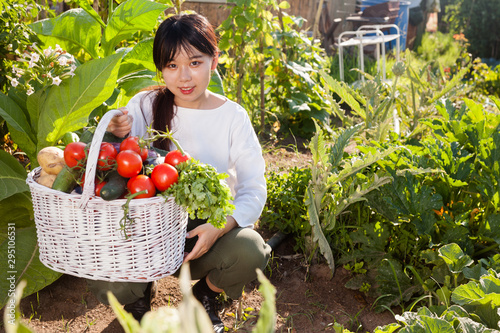 Female holding basket full of vegetables
