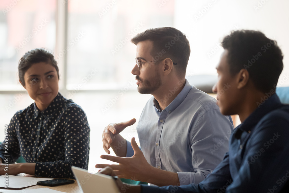 Serious caucasian businessman talk to indian african people group Serious caucasian businessman talk to indian african people group