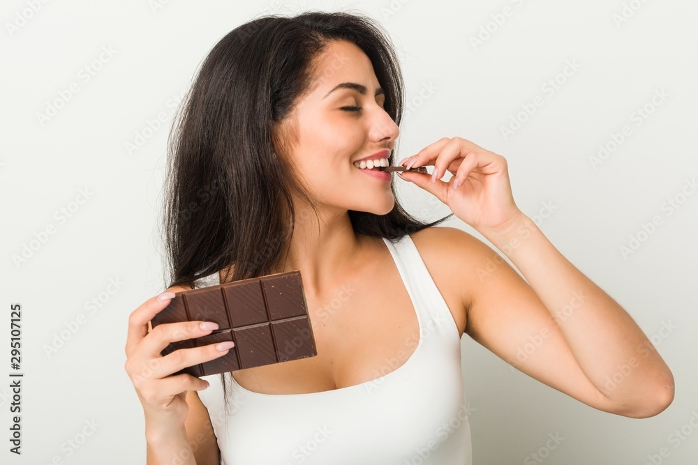 Naklejka premium Young hispanic woman holding a chocolate tablet