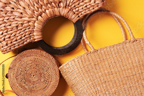 Set of women's straw bags on trendy yellow background. Top view. Copy space. Summer travel concept. Sustainable lifestyle. Zero waste, plastic free concept. photo