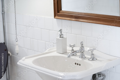 Vintage sink. A vintage bathroom style with sink and soft focus on the stainless tap water.