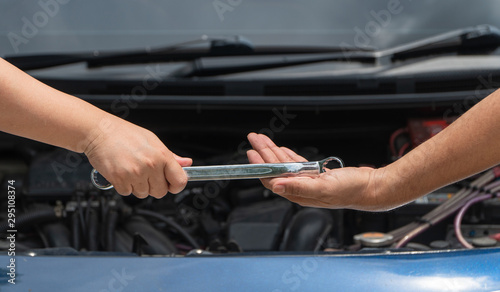 The head of technician the car engine repairman service is sending a wrench to the co-worker. Concept of maintenance vehicle mechanic and automotive