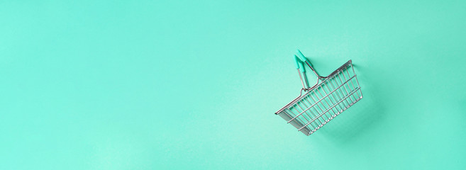 Top view of supermarket shopping basket on trendy green background. Black friday sale concept. Copy space. Sustainable lifestyle.
