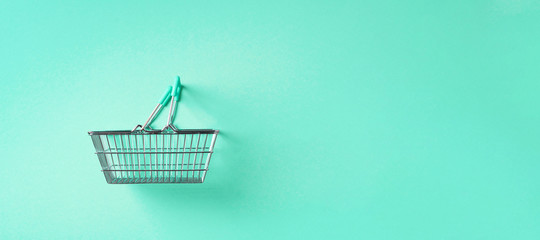 Top view of supermarket shopping basket on trendy green background. Black friday sale concept. Copy space. Sustainable lifestyle.