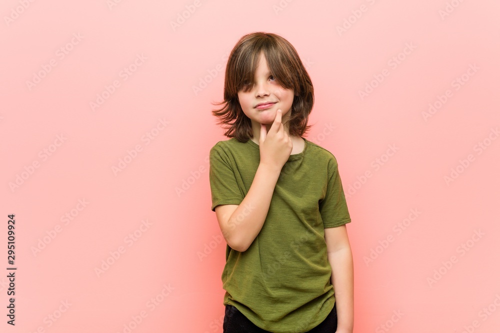 Little boy looking sideways with doubtful and skeptical expression. Little boy looking sideways with doubtful and skeptical expression.