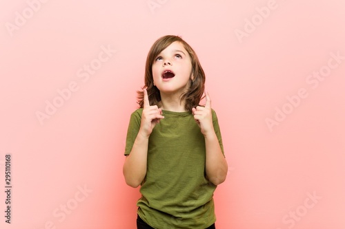Little boy pointing upside with opened mouth.