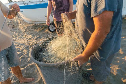 Untangling the net. Fishermen pulling and mending the traditional fishing nets by hand photo
