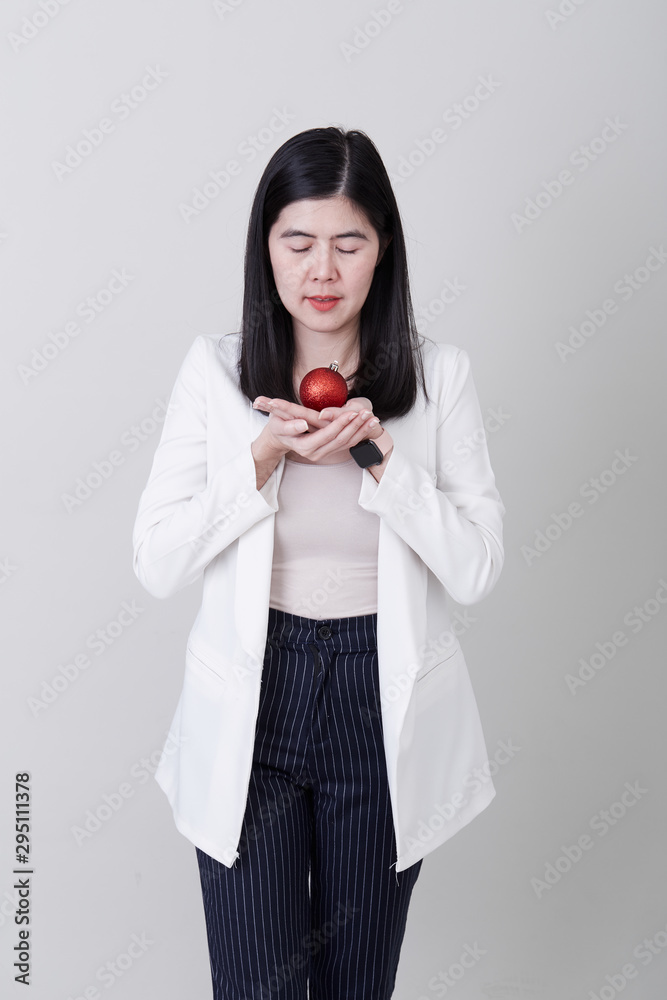Asian woman hand holding a christmas red ball Asian woman hand holding a christmas red ball