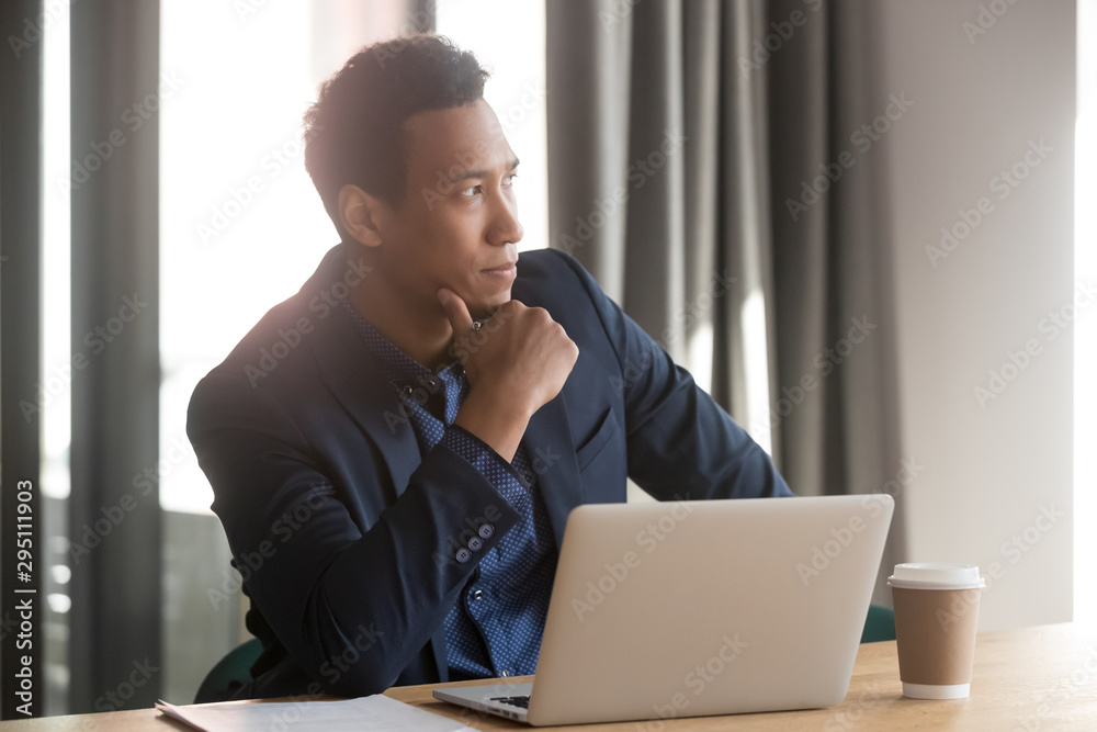 Thoughtful african businessman lost in thoughts sit at office desk Thoughtful african businessman lost in thoughts sit at office desk
