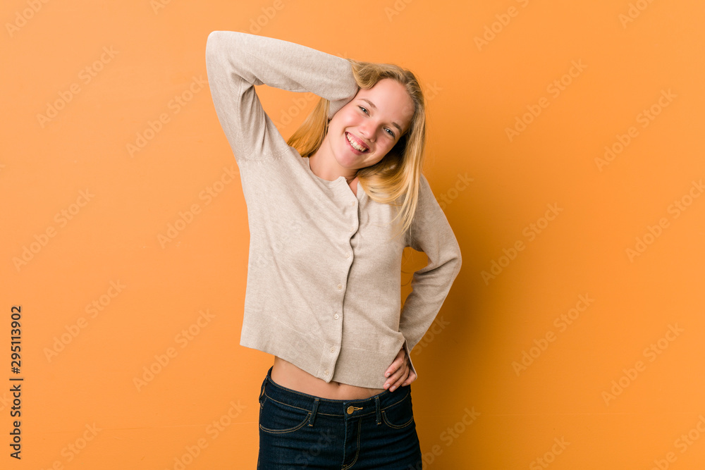 Cute caucasian teenager posing standing against a orange background Cute caucasian teenager posing standing against a orange background