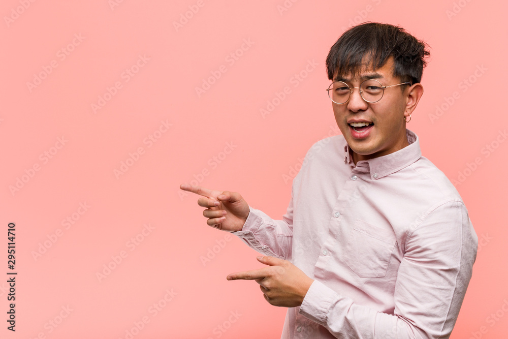 Young chinese man pointing to the side with finger Young chinese man pointing to the side with finger
