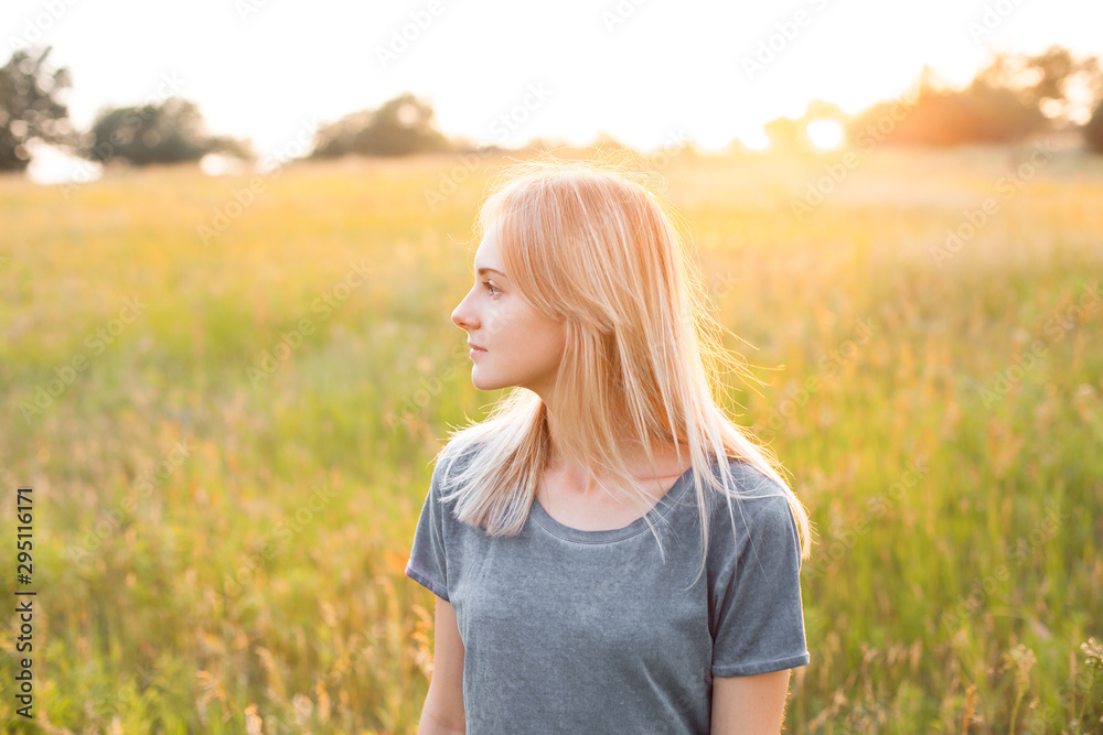 Portrait of young woman on the field at evening Portrait of young woman on the field at evening