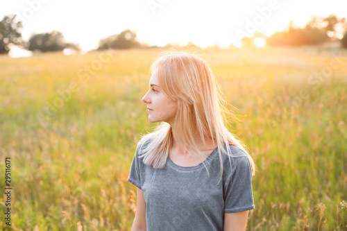 Portrait of young woman on the field at evening