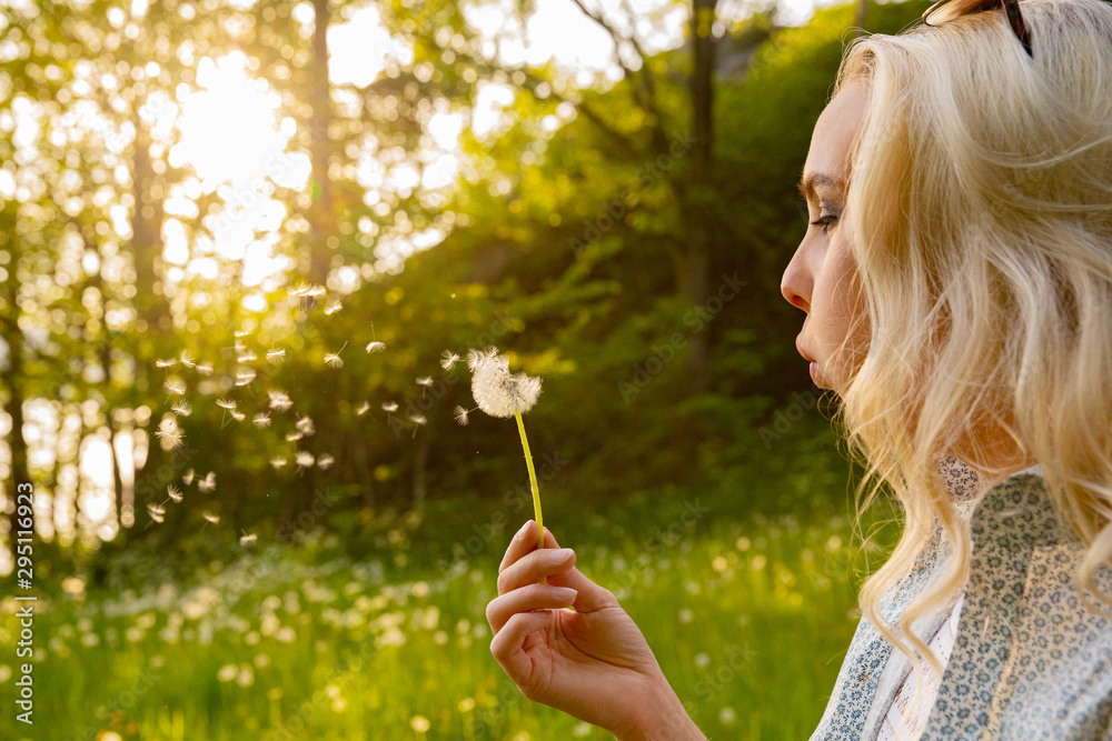 Closeup Of Young Woman Blowing Dandelion Seeds Closeup Of Young Woman Blowing Dandelion Seeds