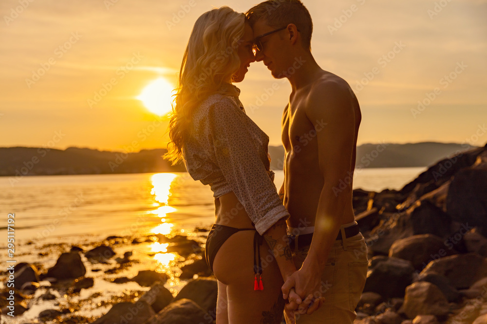 Fototapeta premium Young Romantic Couple Holding Hands At Beach During Sunset