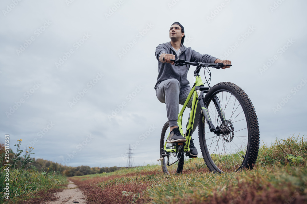 A man on a bicycle in the autumn on a field road A man on a bicycle in the autumn on a field road