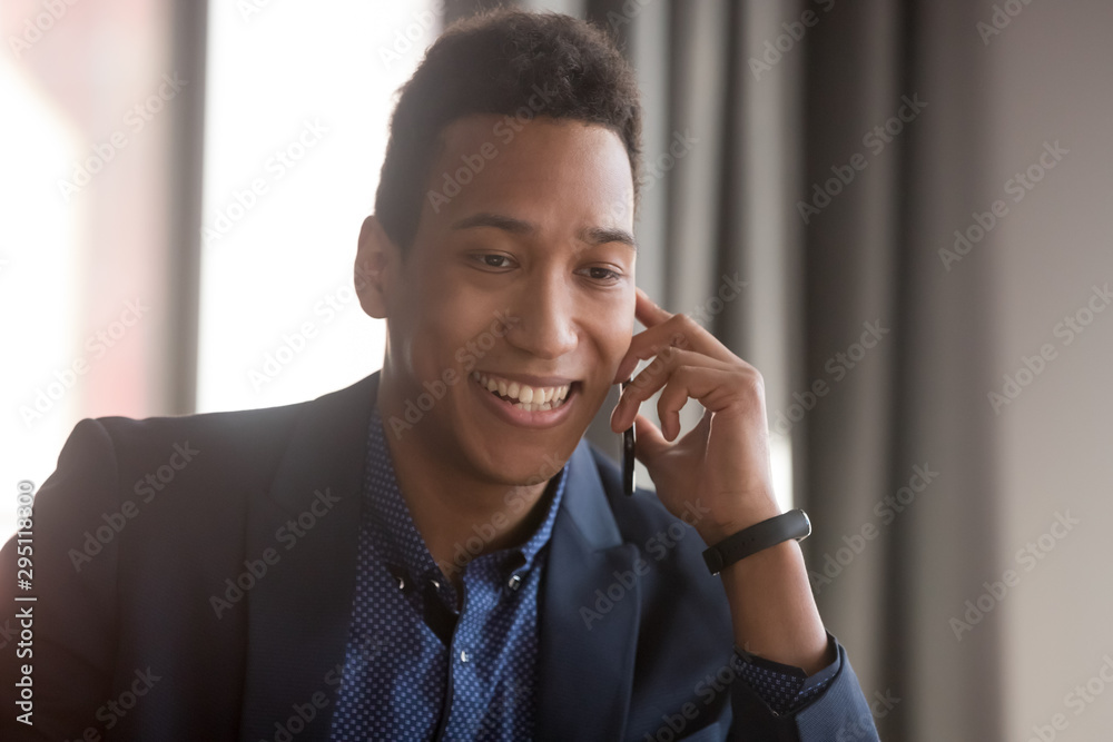Happy african american business man talking on phone in office Happy african american business man talking on phone in office