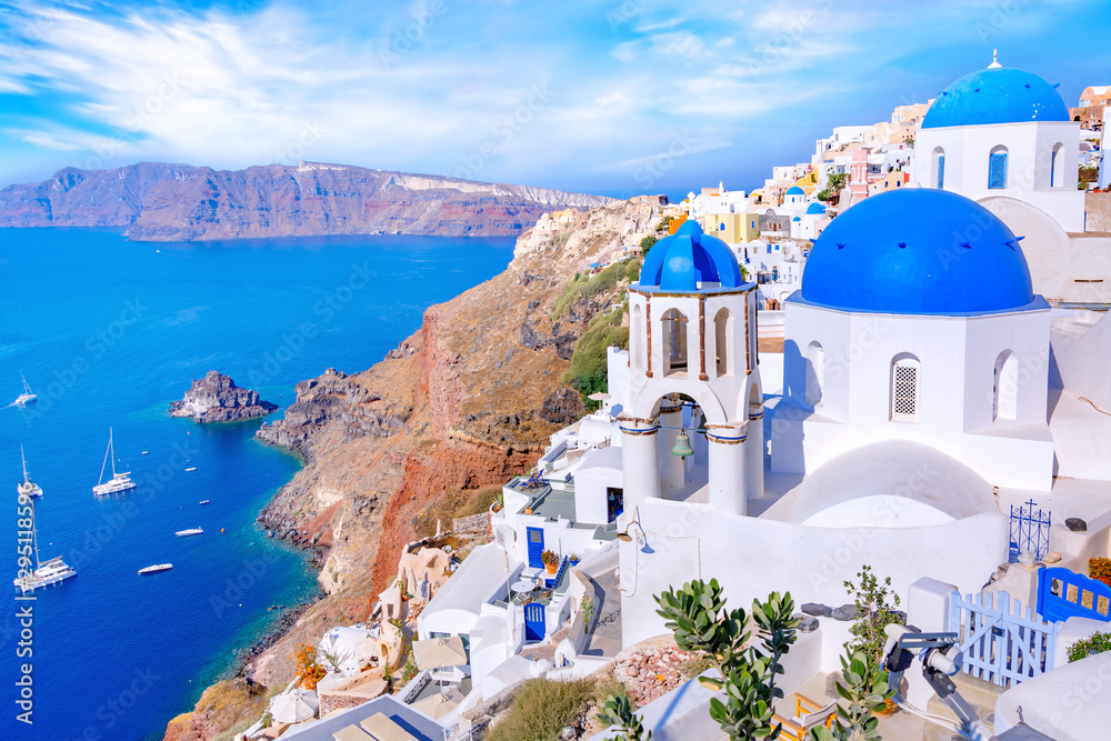 Fototapeta Piękny miasteczko Oia na wyspie Santorini, Grecja. Tradycyjna biała architektura i greccy ortodoksyjni kościół z błękitnymi kopułami nad kalderą w morzu egejskim, Grecja. Malownicze tło podróży.