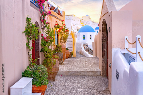 Wąska sceniczna ulica Oia wioska na Santorini wyspie przy zmierzchem, Grecja.