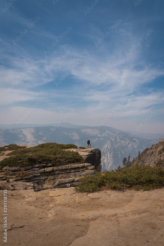 Adventure travel hiking standing on the edge of a cliff in Yosemite National Park