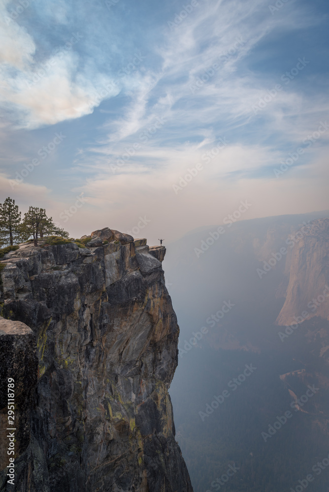 Tiny person in big world standing on cliff in Yosemite National Park