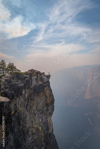 Tiny person in big world standing on cliff in Yosemite National Park
