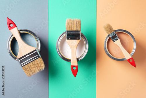 Fototapeta Naklejka Na Ścianę i Meble -  Metal paint cans and paint brushes on multicolor background. Top view. Copy space. Trendy green color concept