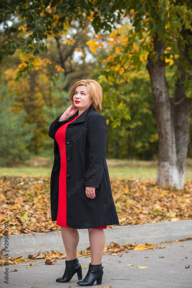 Beautiful mature fashionable woman on a walk in the city. Season time. A nice middle aged plus size woman standing on the street. Plump women lifestyle Beautiful mature fashionable woman on a walk in the city. Season time. A nice middle aged plus size woman standing on the street. Plump women lifestyle