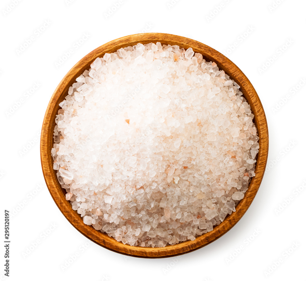 Salt in a wooden plate on a white background. The view of top. Salt in a wooden plate on a white background. The view of top.
