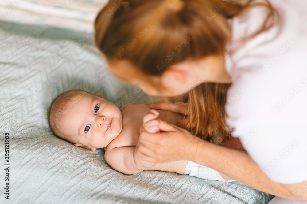 Mom hugs with her newborn baby in bed. Four month old baby. Baby care, tenderness, motherhood Mom hugs with her newborn baby in bed. Four month old baby. Baby care, tenderness, motherhood