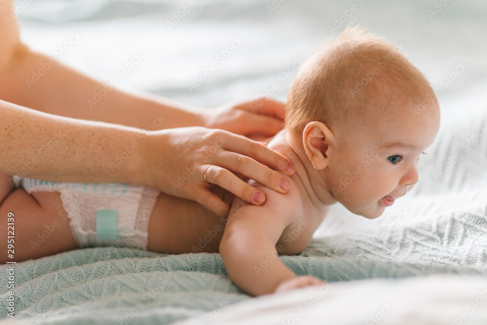 Massage for the baby. Four month old baby smiling doing gymnastics Massage for the baby. Four month old baby smiling doing gymnastics