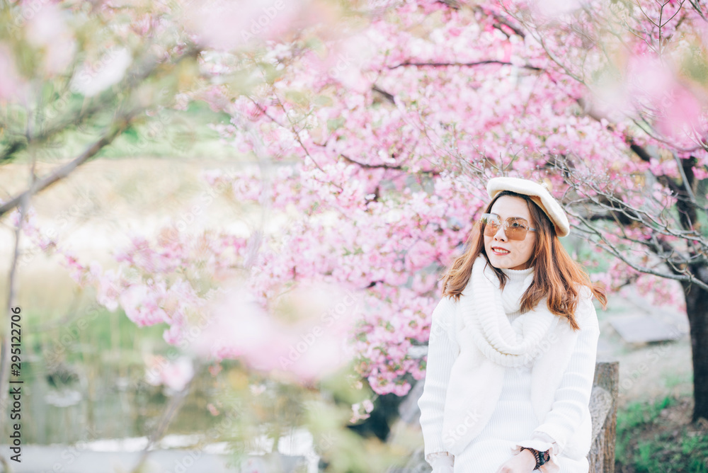 Happy travel woman and smile with sakura cherry blossoms tree on vacation while spring, asian Happy travel woman and smile with sakura cherry blossoms tree on vacation while spring, asian