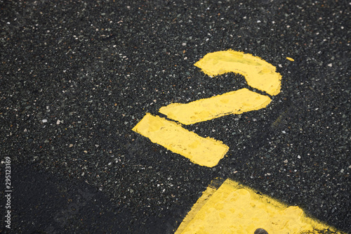 yellow number two isolated road sign painted on asphalt for background, motor race start number