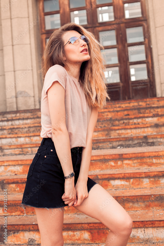 Young fashionable woman posing in the city. Warm colors Young fashionable woman posing in the city. Warm colors