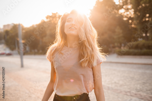 Happy woman woman with beautiful hair walking in the city under sunlight