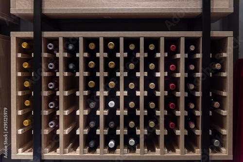 Wine bottles horizontally laid in wooden square box shelf photo