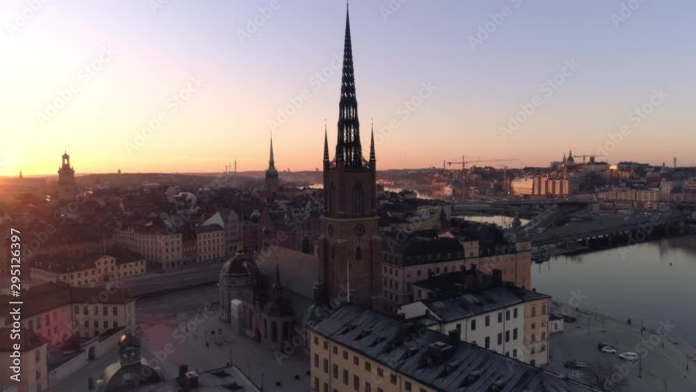 Stockholm downtown city skyline at sunrise aerial view. Drone shot orbiting around church tower building on Riddarholmen island in central Stockholm. Old Town, Gamla stan landmark, Capital of Sweden