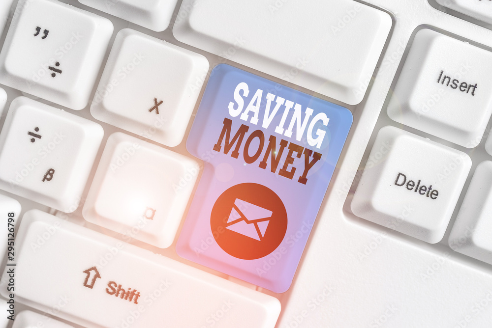 Conceptual hand writing showing Saving Money. Concept meaning putting money in an account in a bank o financial organization White pc keyboard with note paper above the white background Conceptual hand writing showing Saving Money. Concept meaning putting money in an account in a bank o financial organization White pc keyboard with note paper above the white background