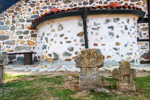 Two ancient stone crosses in front of St. Petka Eastern Orthodox Church in Tsari Mali Grad fortress in Belchin, Bulgaria photo