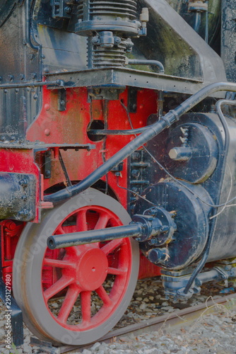 Detail: red metal wheel and other mechanisms of a vintage locomotive