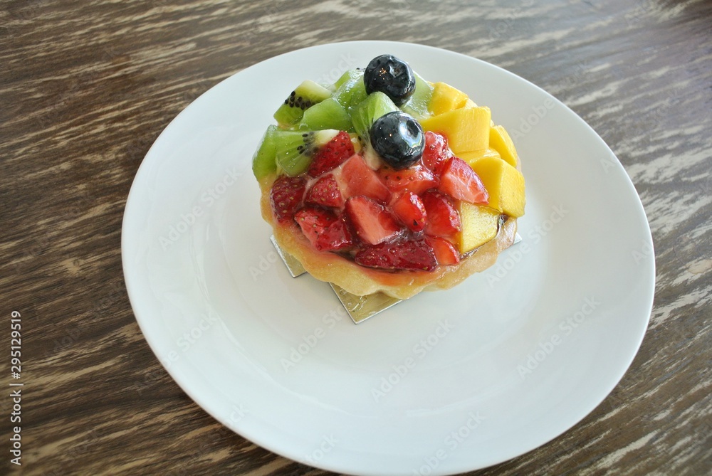 Cobbler tarts on wood tables, mango, strawberries, kiwi, blueberries Cobbler tarts on wood tables, mango, strawberries, kiwi, blueberries