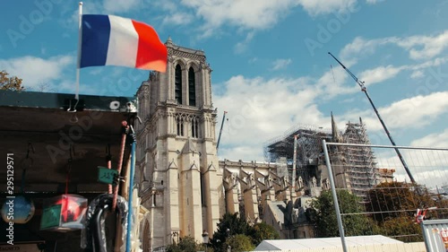 Paris, France - September 2019: Reconstruction of the Notre-Dame de Paris Cathedral burnt in a fire. Against the background of the flag of France. Togetherness concept