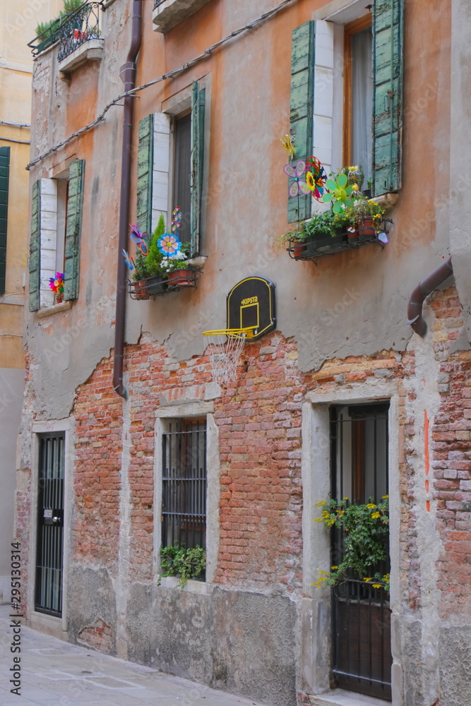 Residential courtyard in Venice, window decorations for children, basketball net
