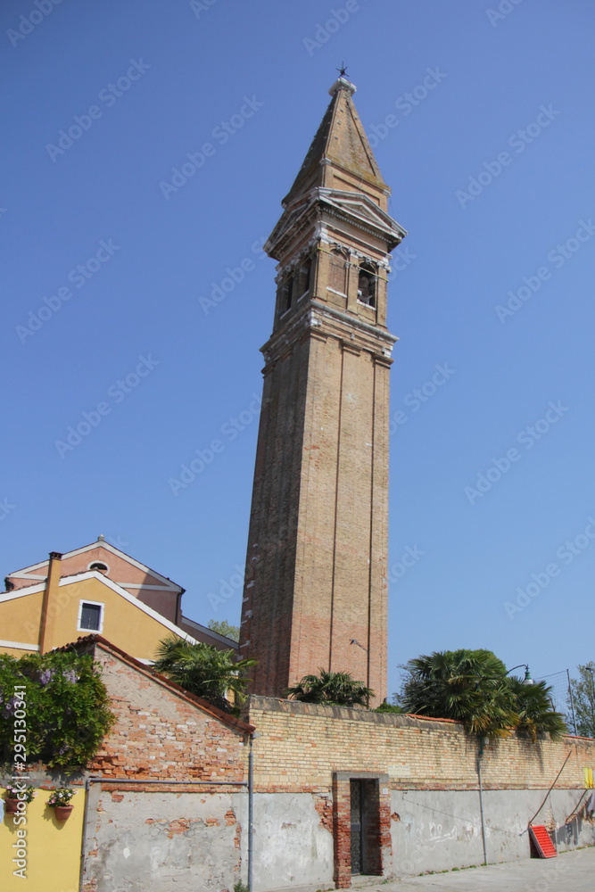 An ancient tower that leans from old age, on the island of Burano, Venice. Deserted
