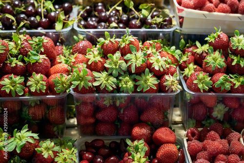 Bright fresh strawberries, raspberries, cherries, fruits and berries. Farmers market with vegetables and fruits, open shelves of shop windows. Healthy organic food, harvest