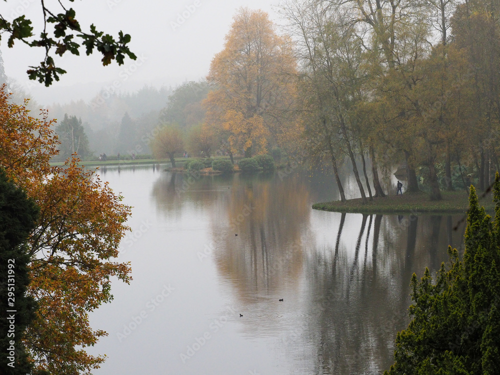 Fototapeta premium Mist and Autumn colour in the reflected in lake