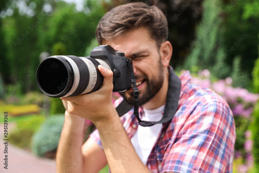 Photographer taking photo with professional camera in park