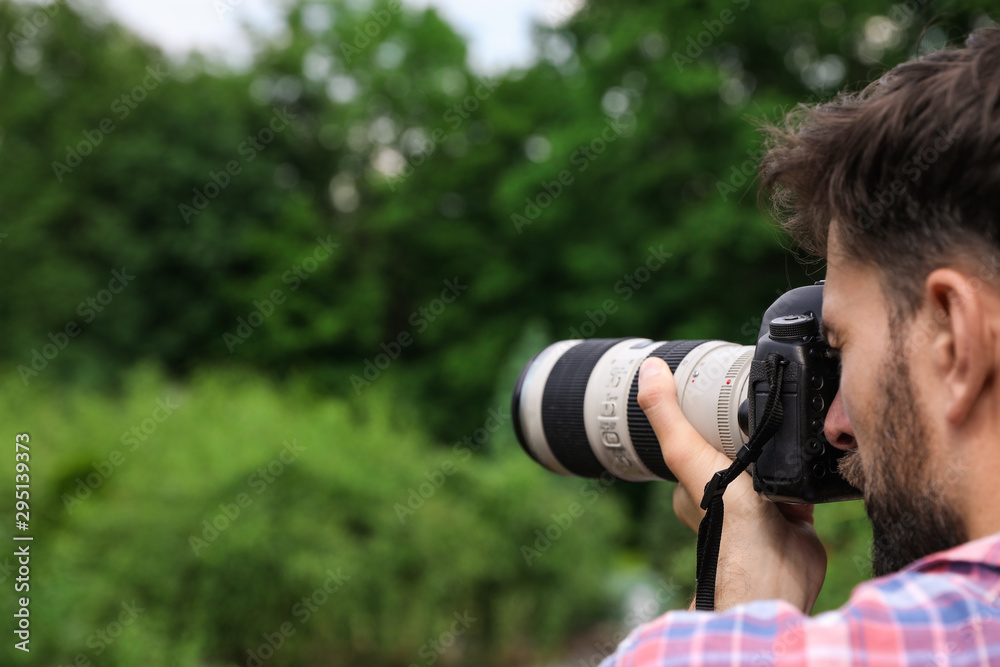 Photographer taking photo with professional camera in park