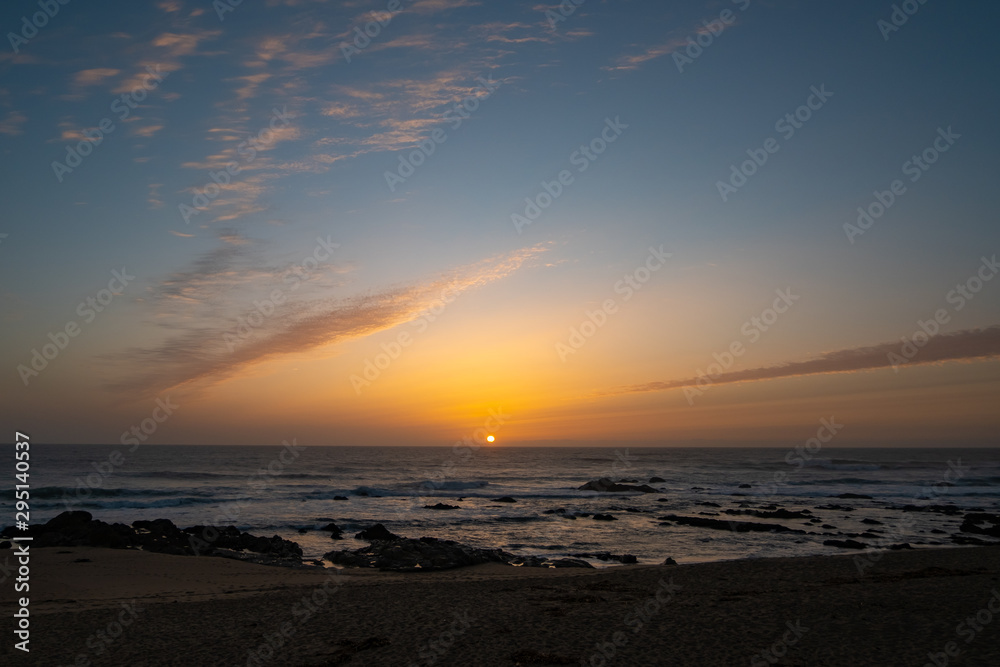 Sun on horizon at sunset on beach in Portugal. Early autumn.